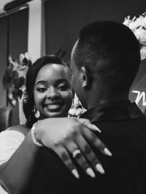 Intimate moment captured between couple during proposal under floral arch.