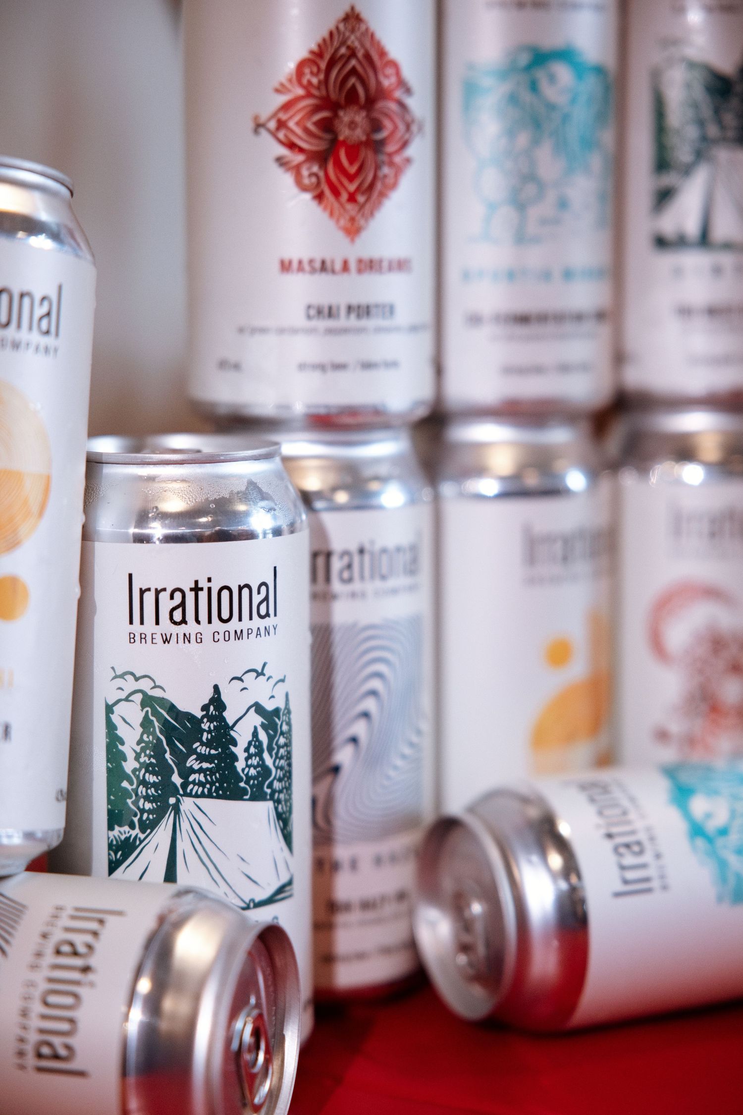 Irrational Brewing Company beer cans displayed, featuring Masala Dreams Chai Porter and other craft beer varieties.