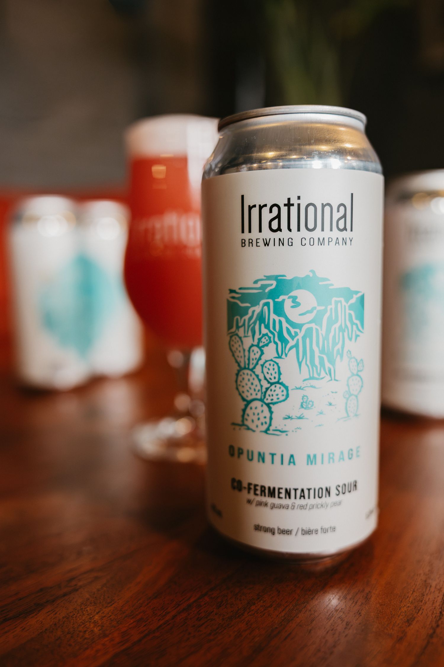 Irrational Brewing Company Opuntia Mirage co-fermentation sour beer can on a wooden table.