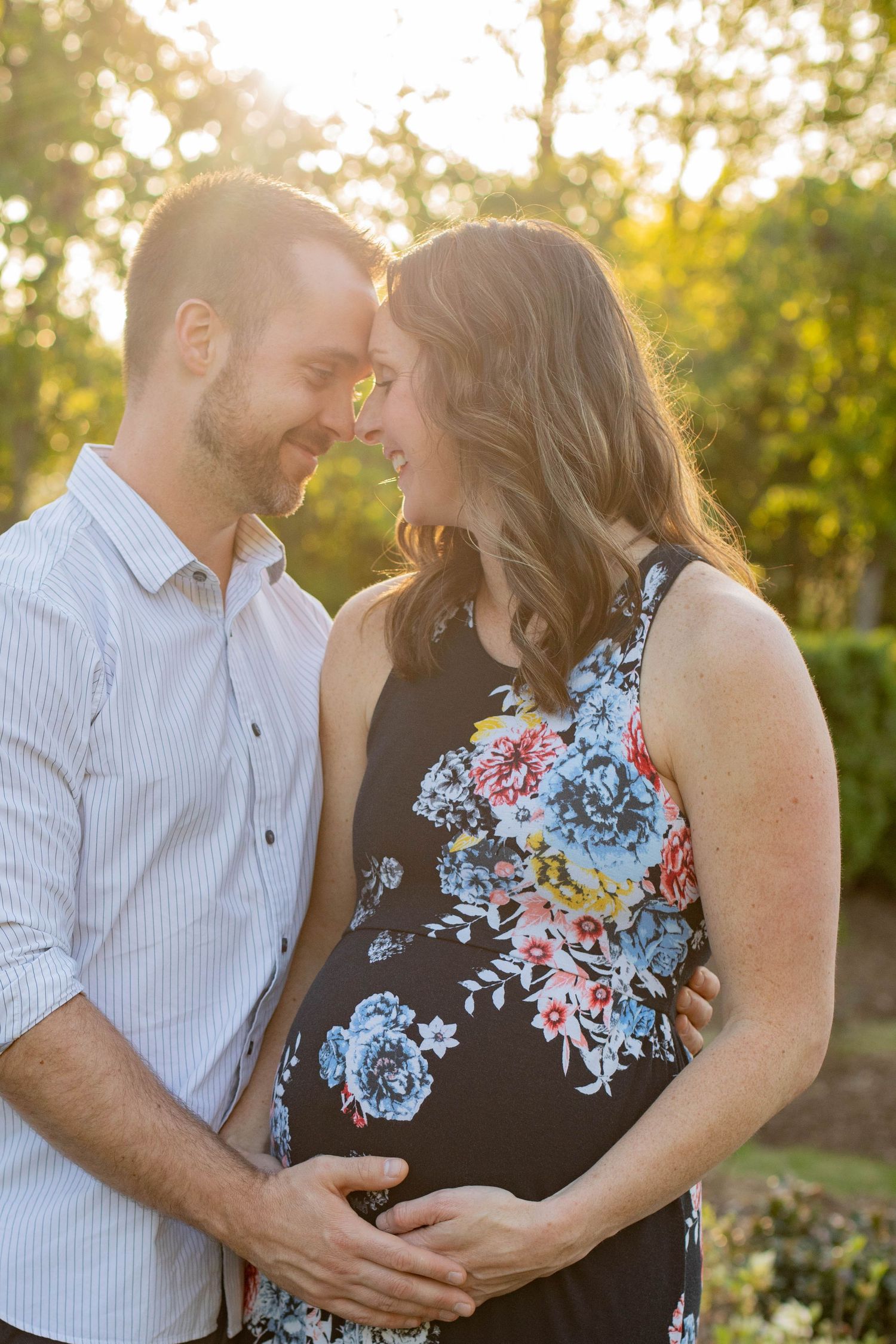 Intimate maternity photos of couple embracing in golden evening light.