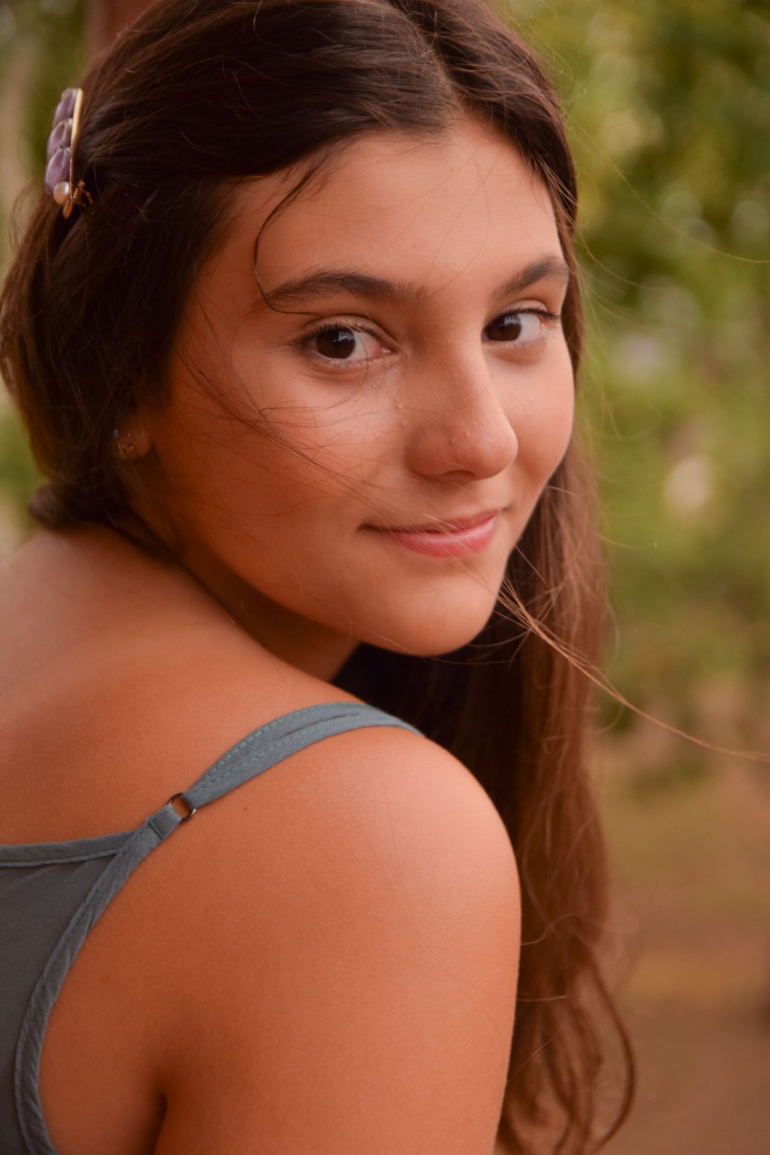 A natural outdoor portrait with warm lighting and a grey tank top.