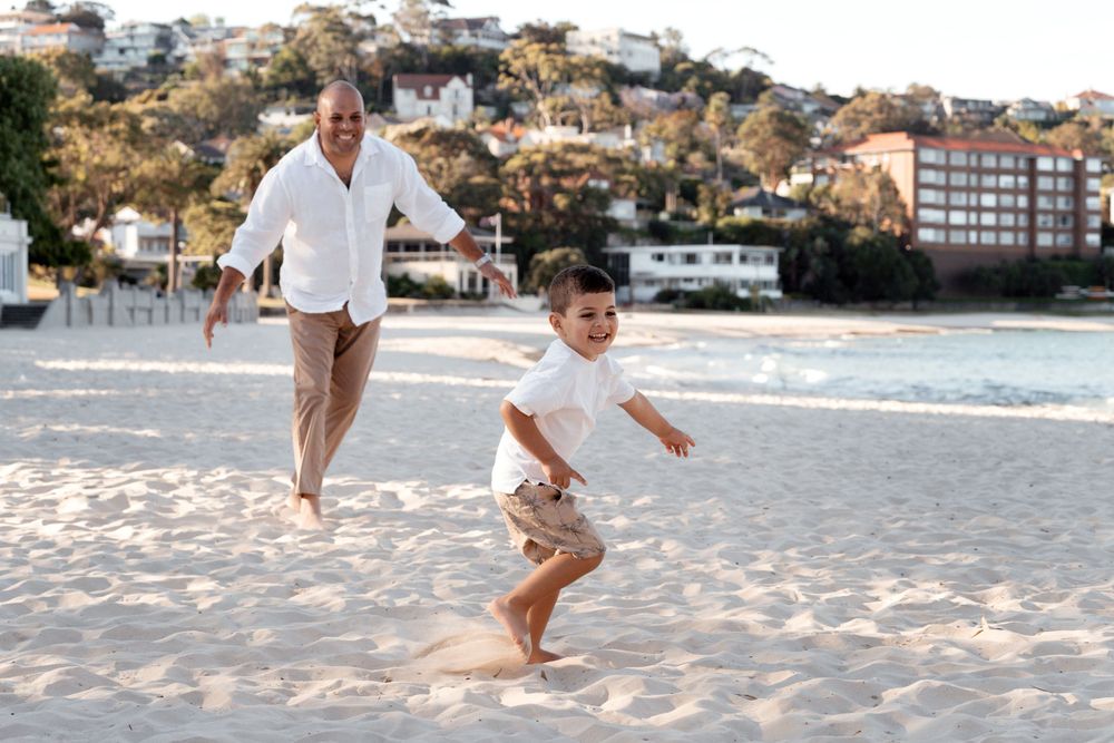 dad chasing son during family photoshoot at balmoral beach