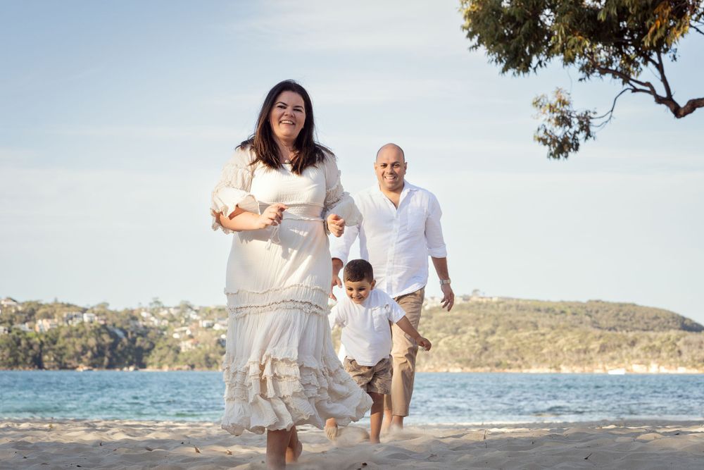 family is playing catch during family photoshoot at balmoral beach Mosman