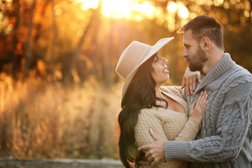 Romantic couple embracing at sunset with warm golden light filtering through trees sunset photo session in Murfreesboro, TN