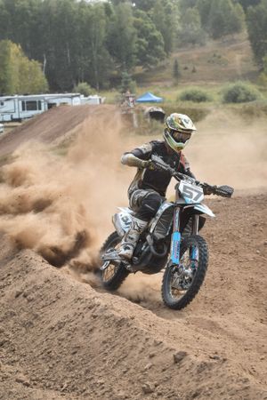 Dirt bike rider kicks up dust while cornering on a motocross track through multiple action shots.