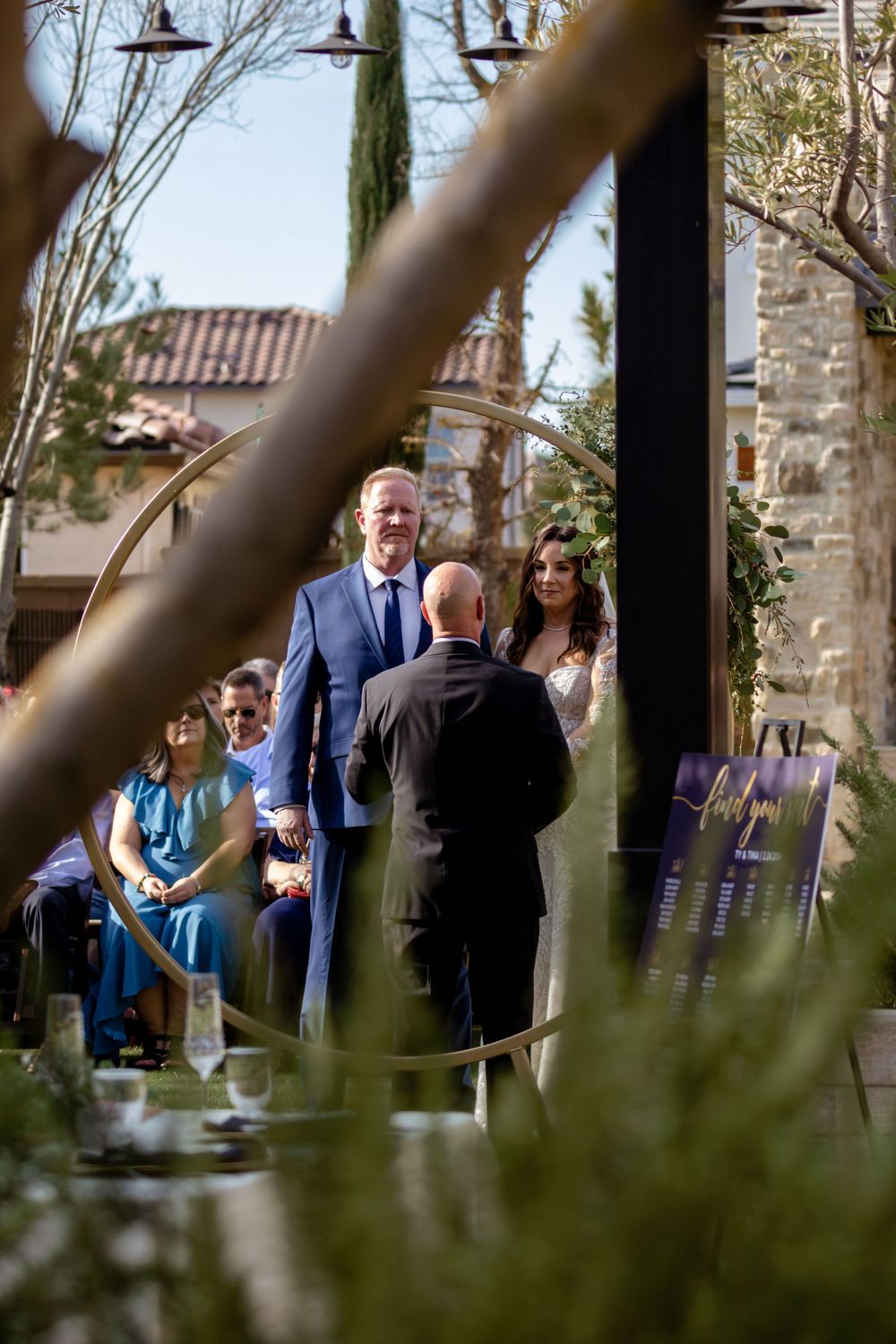 Guests socializing beneath hanging lights at an outdoor evening event.