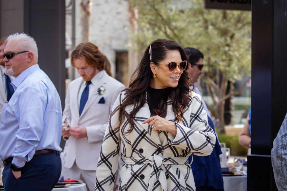 Guests in formal attire socializing during an outdoor celebration.