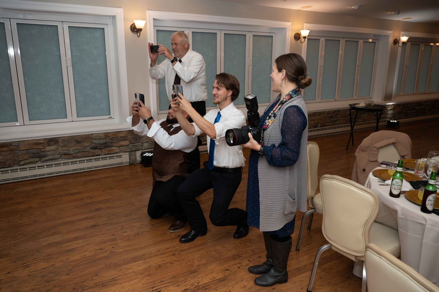 Wedding photographers capturing reception moments with professional cameras in an indoor venue.
