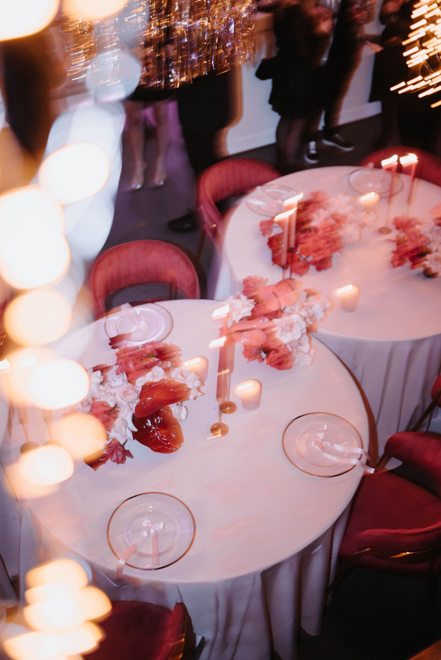 An elegantly set round reception table with candles and floral decorations.