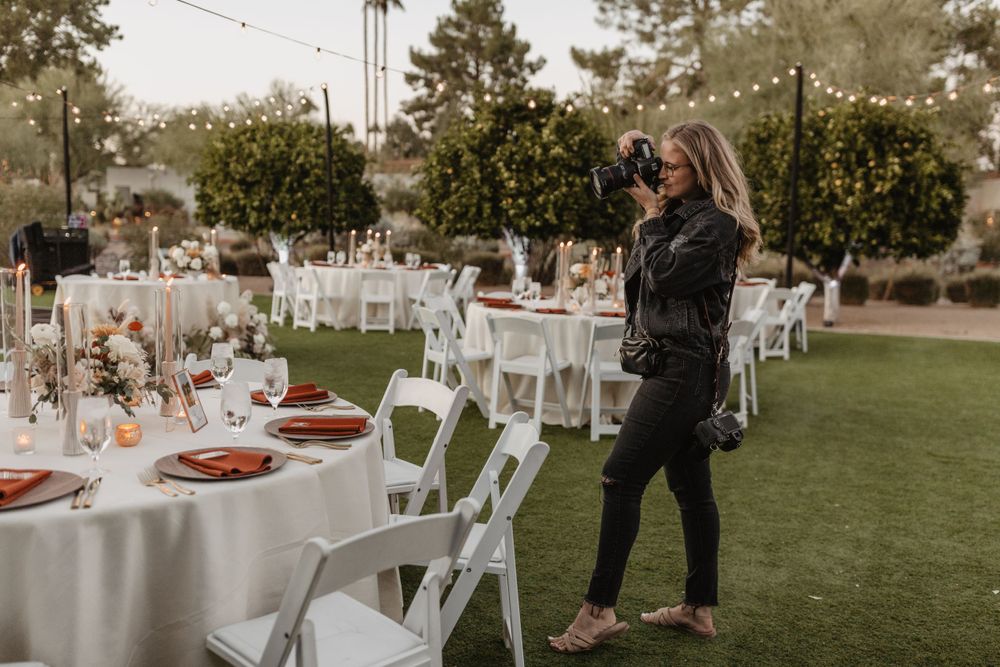 An outdoor wedding reception setup with white tables and chairs on a manicured lawn at dusk. Arizona wedding photographer. The Andaz