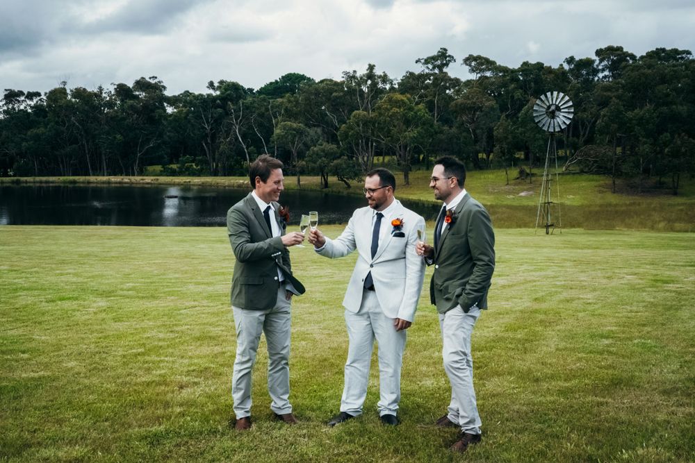 Group photos being taken on a vast green lawn with trees in background.