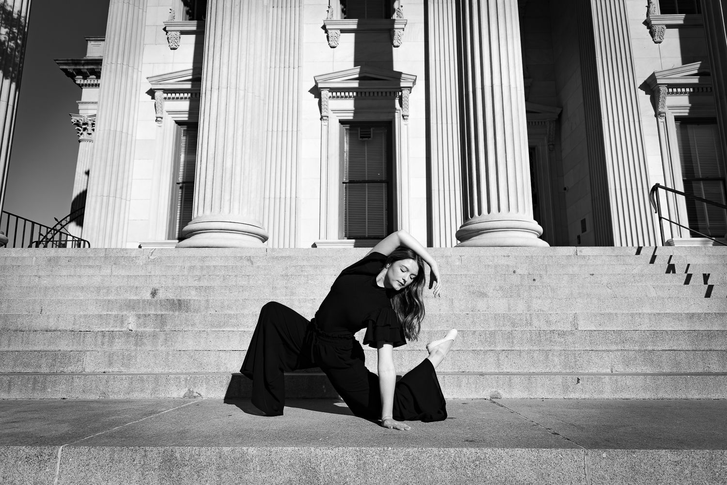 A black and white photo showing architecture with classical columns and stone steps.