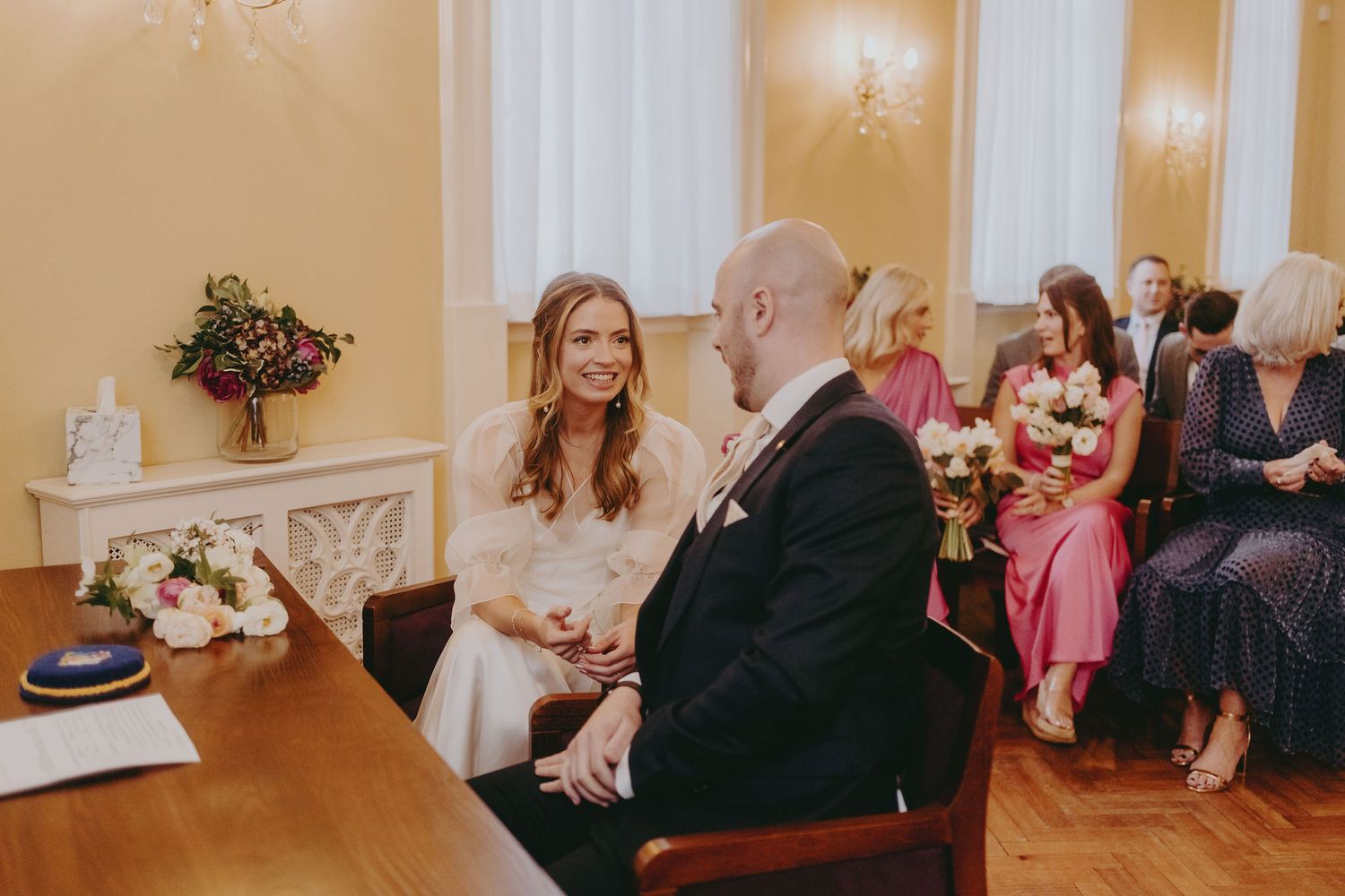Intimate moment during civil ceremony with wedding couple at registration table.