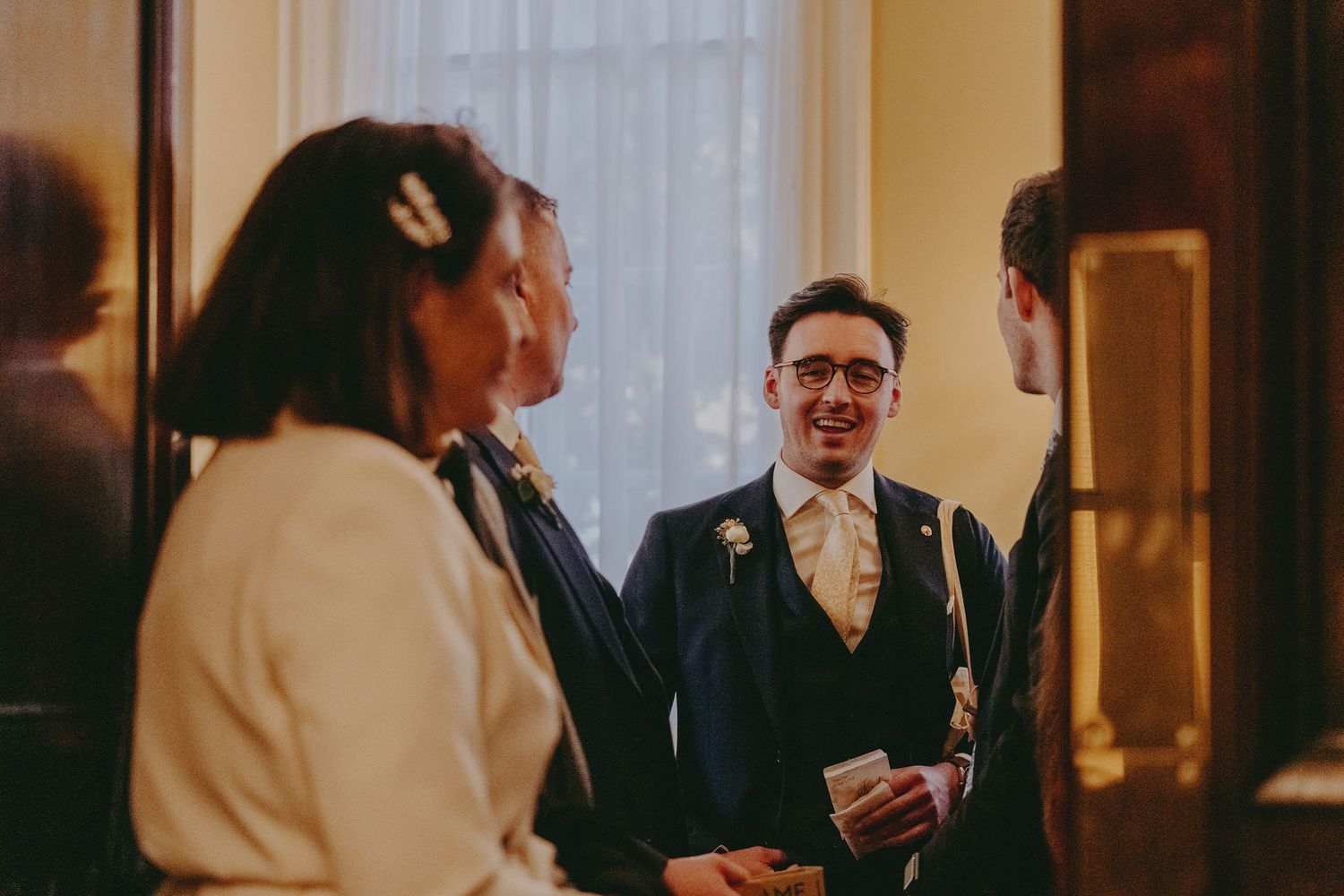 Wedding guests engaging in conversation during an indoor reception.
