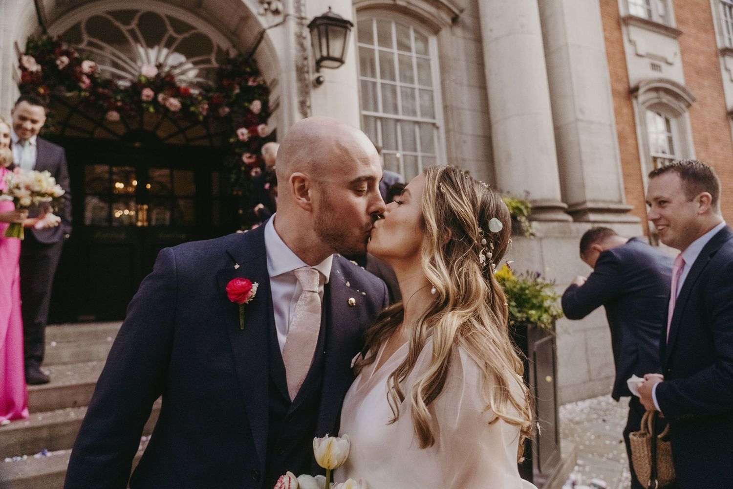 Romantic moment shared on ornate stone steps during wedding celebration.