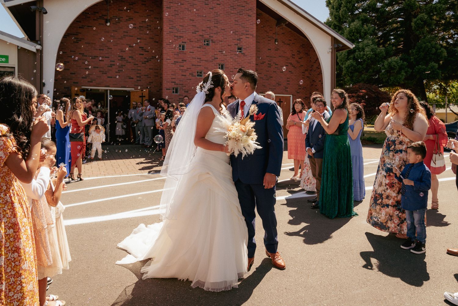Wedding party dances outside church, post-ceremony joy in Oregon.