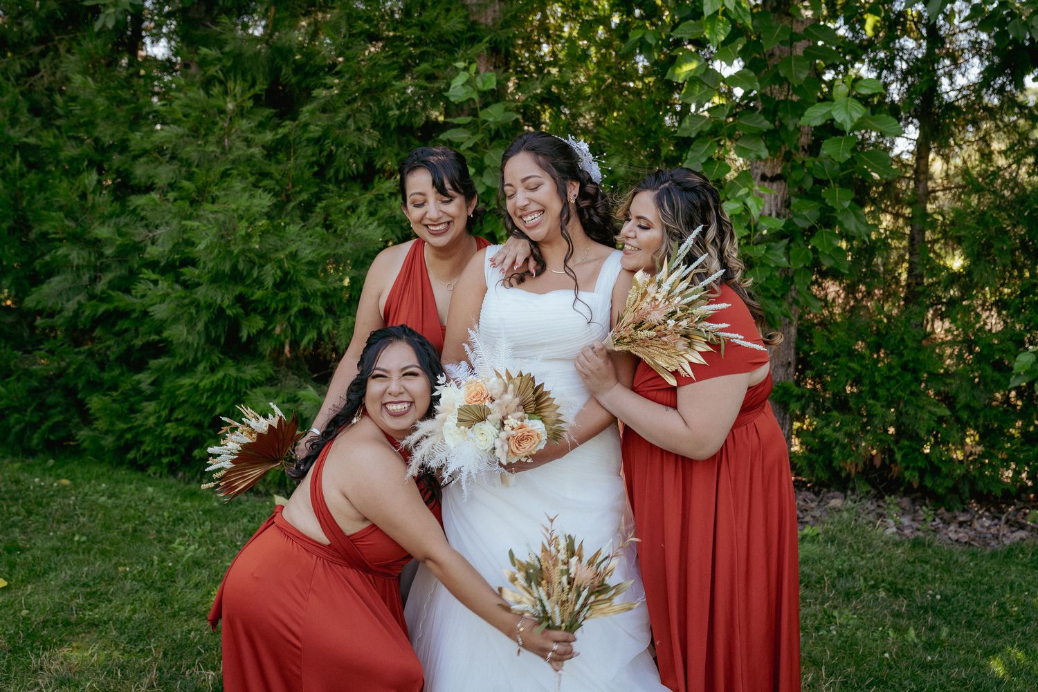 Bride with bridesmaids in rust and cream, joyful Oregon backyard wedding.