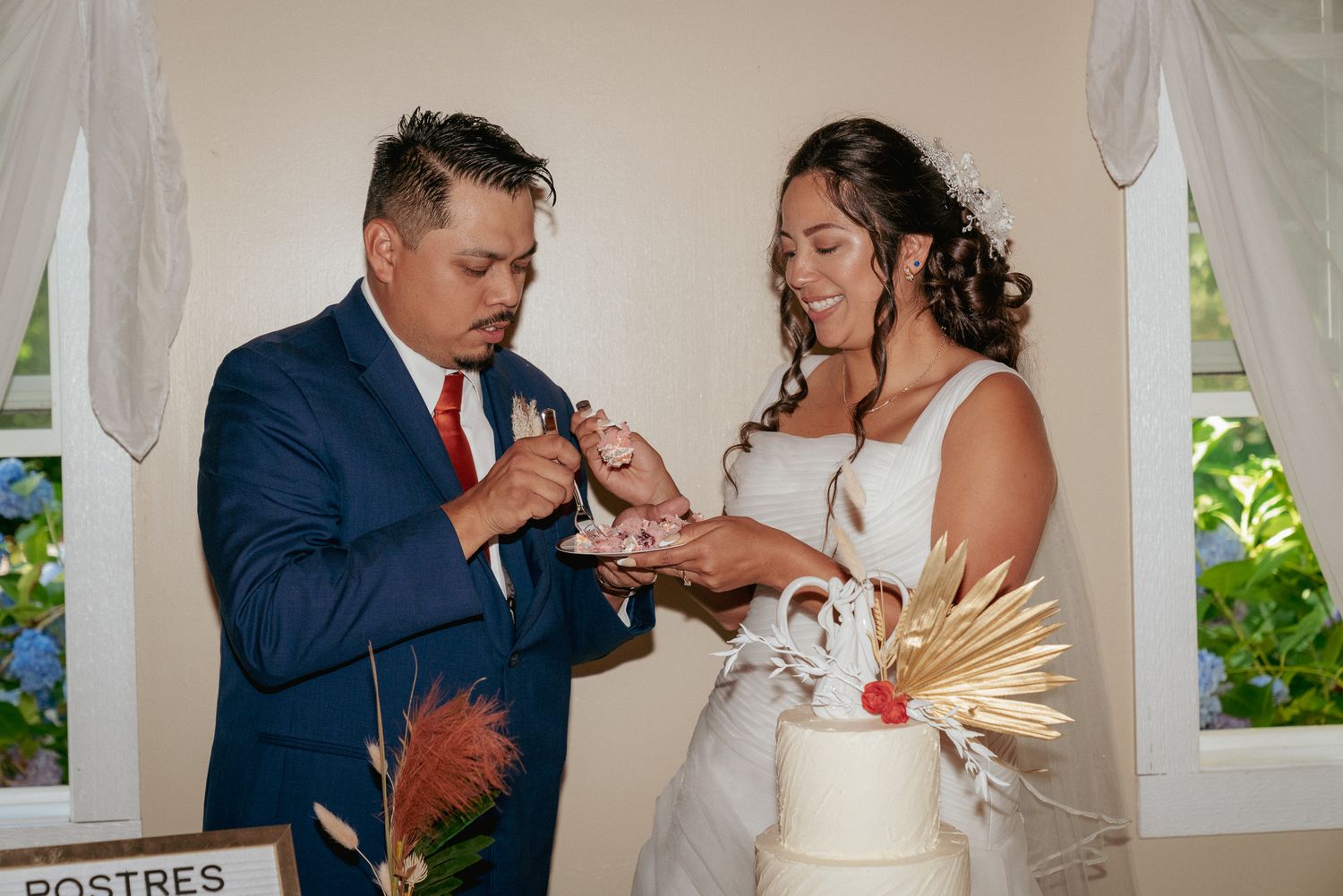 Couple cuts wedding cake in candid moment, backyard Portland wedding.