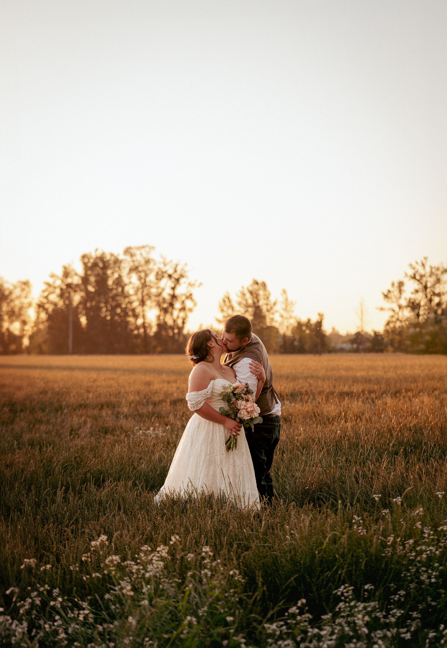 Newlyweds couple strolls through field at golden hour, PNW elopement.