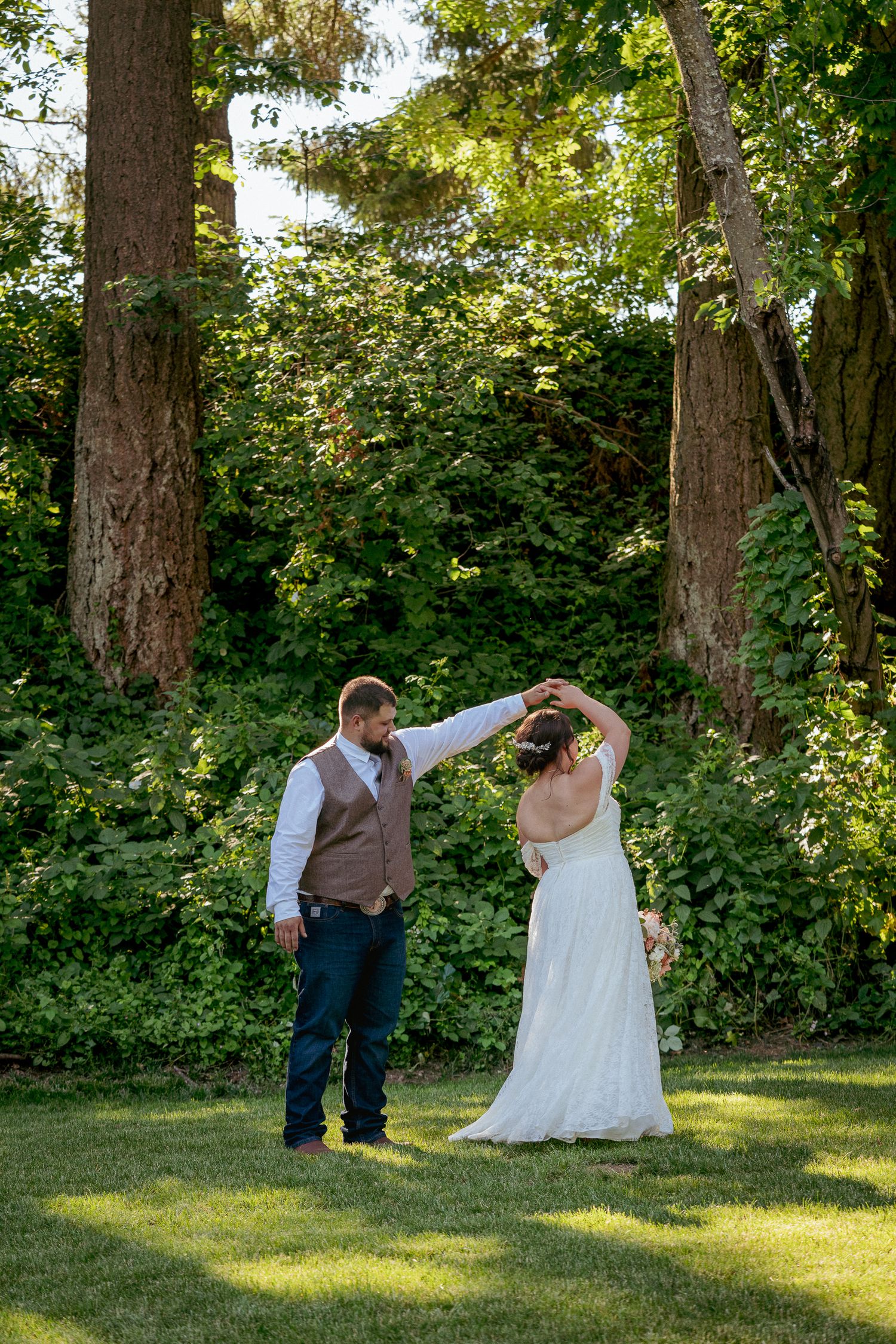 Interracial couple dances in forest clearing, Oregon outdoor wedding.