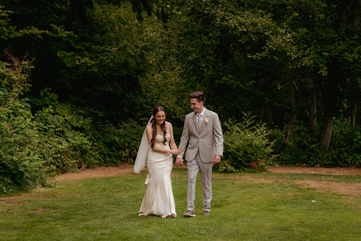 Interracial couple walks hand-in-hand through forest, Oregon vows.