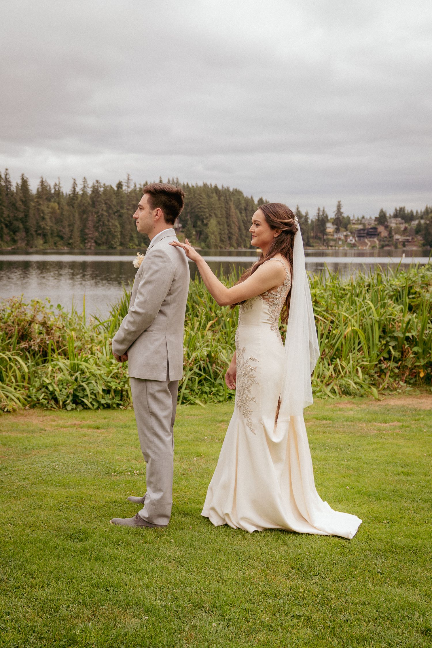 Bride tapping the groom on the shoulder for first look, lakeside Oregon wedding.