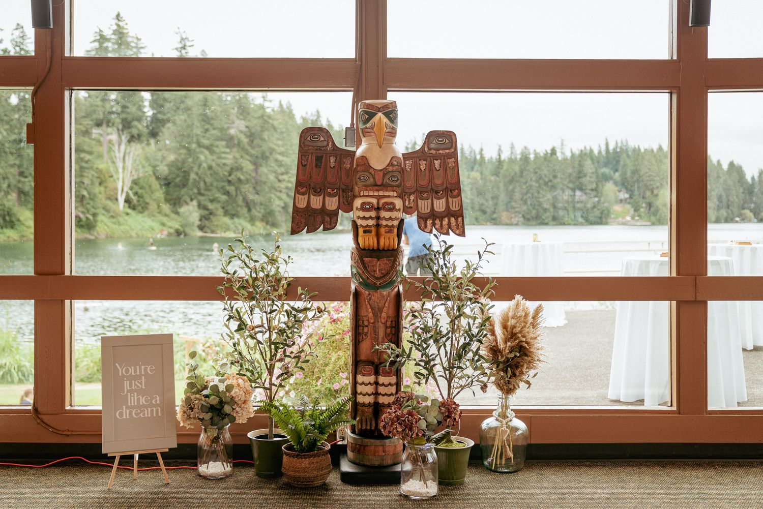 Native wood carving with plants and water view, Oregon cultural venue.