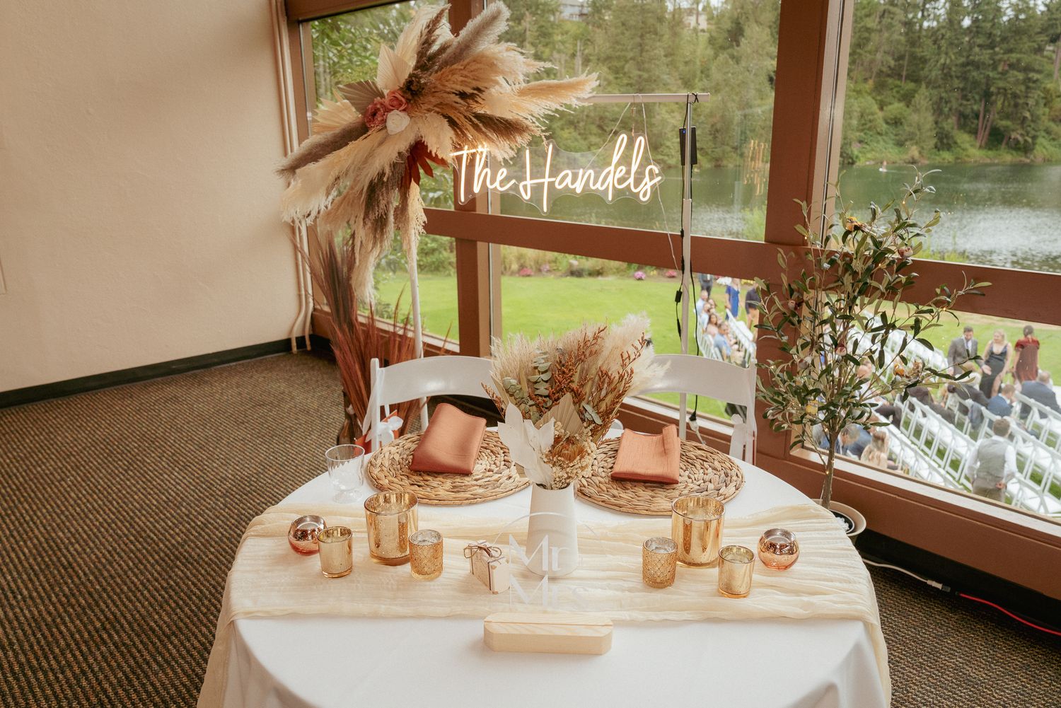 Boho wedding table setup with hats and candles, modern rustic details.