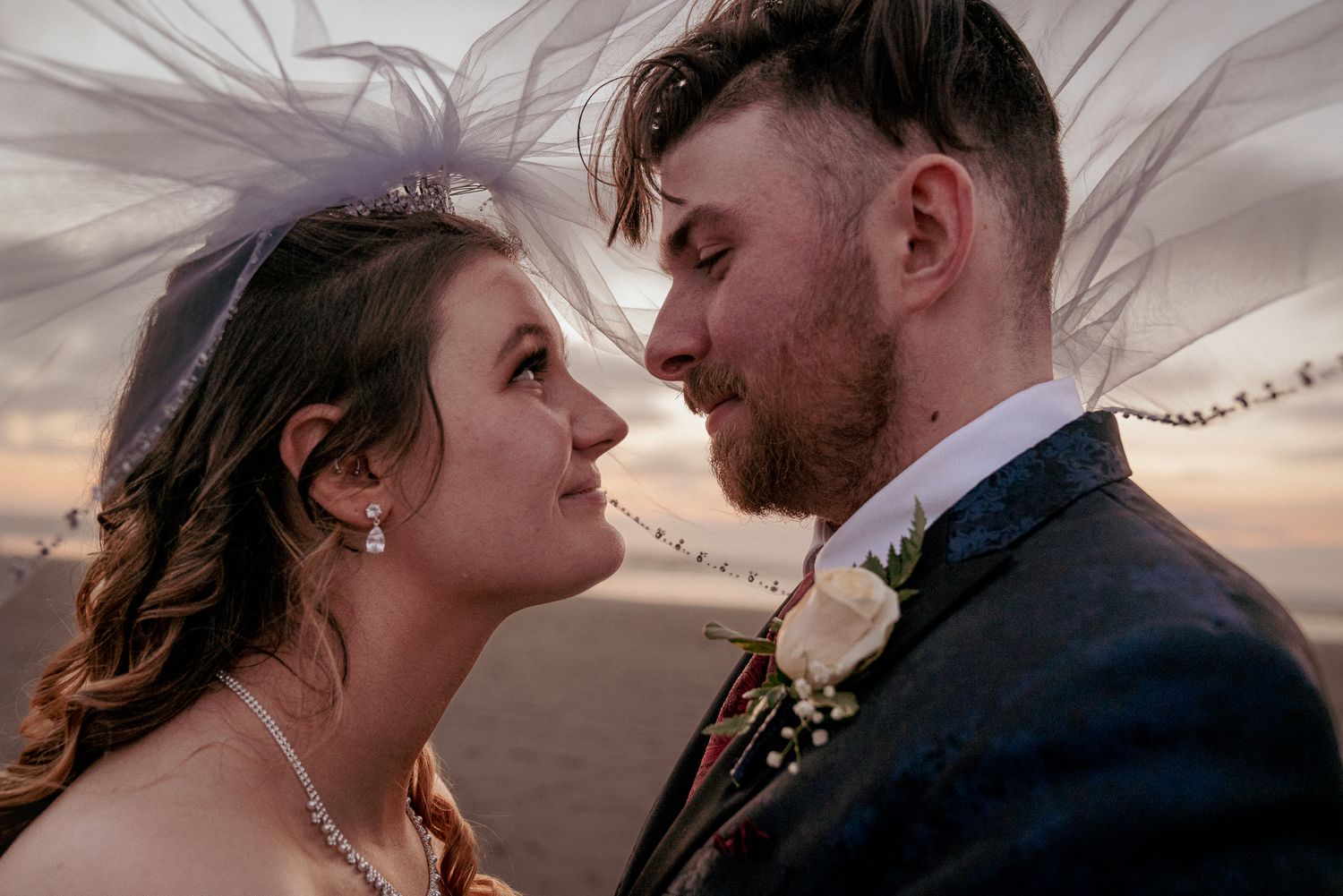 Interracial couple shares close moment, Oregon Coast wedding romance.