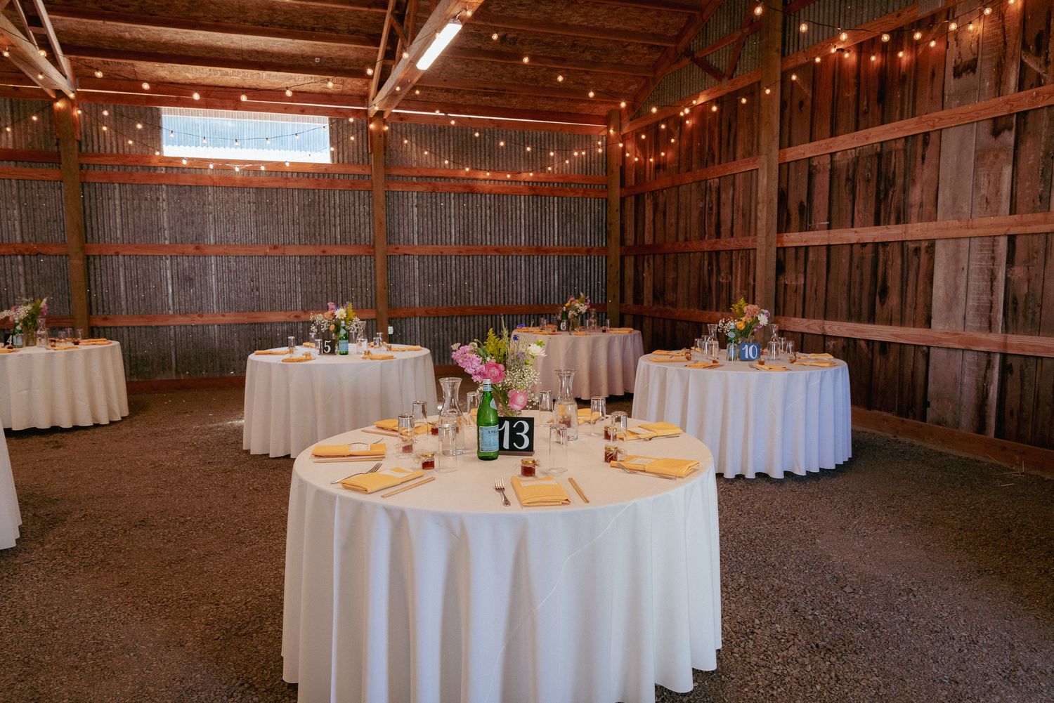 Barn wedding reception setup with string lights, rustic PDX charm.