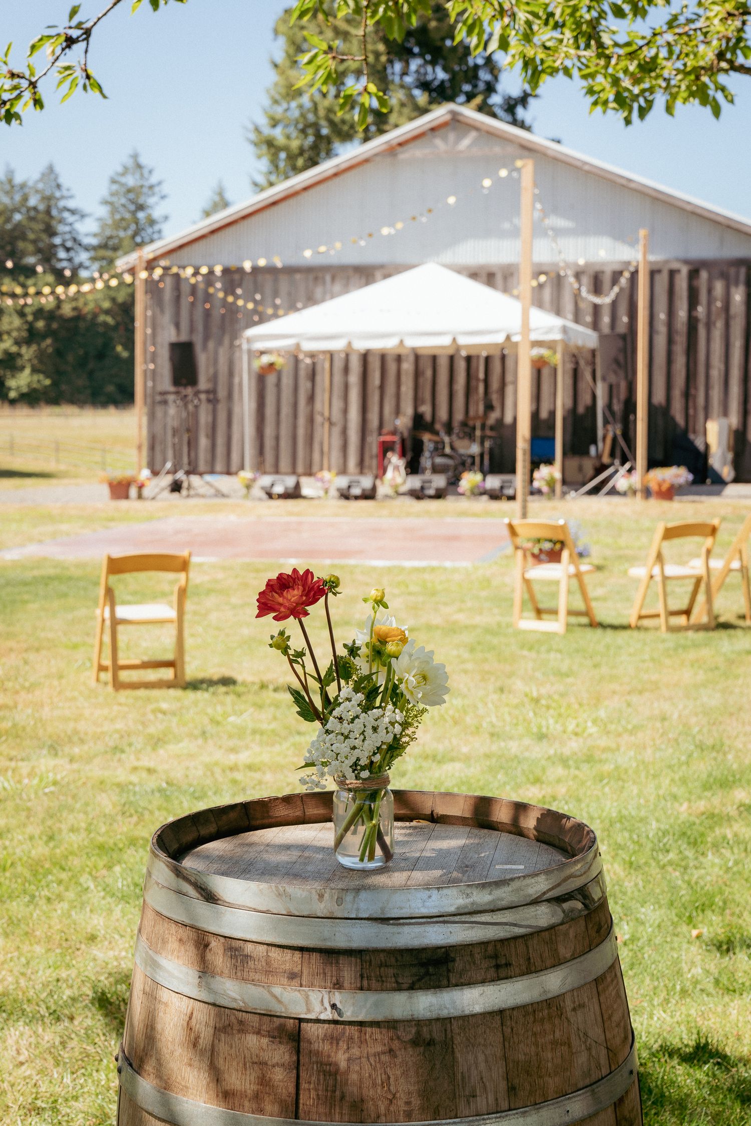 Outdoor wedding lounge setup with vintage chairs, PNW barn venue.