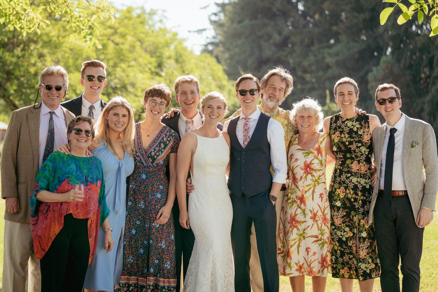 Wedding guests pose with newlyweds, inclusive and joyful PNW group photo.