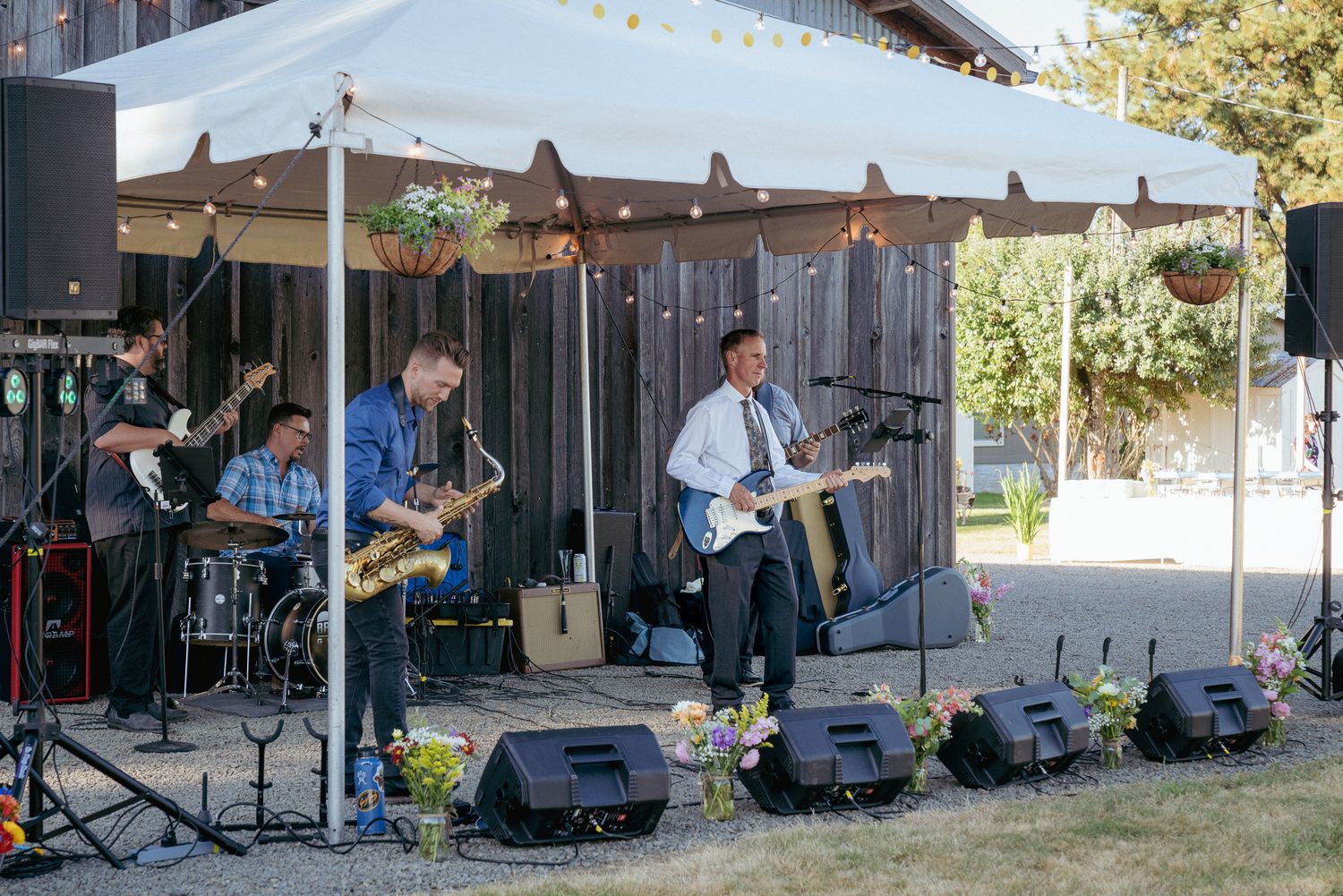 Live band performs under white tent, fun outdoor Portland wedding reception vibes.