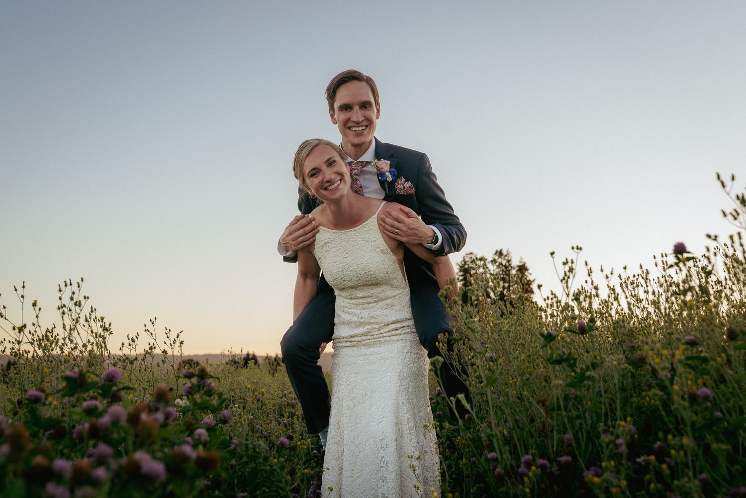 Joyful bride on groom’s back, laughing during Oregon vineyard elopement.