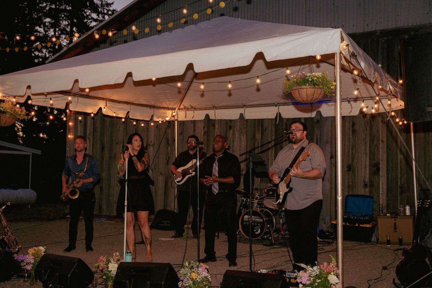 Live band plays under tent lights, outdoor Portland reception.