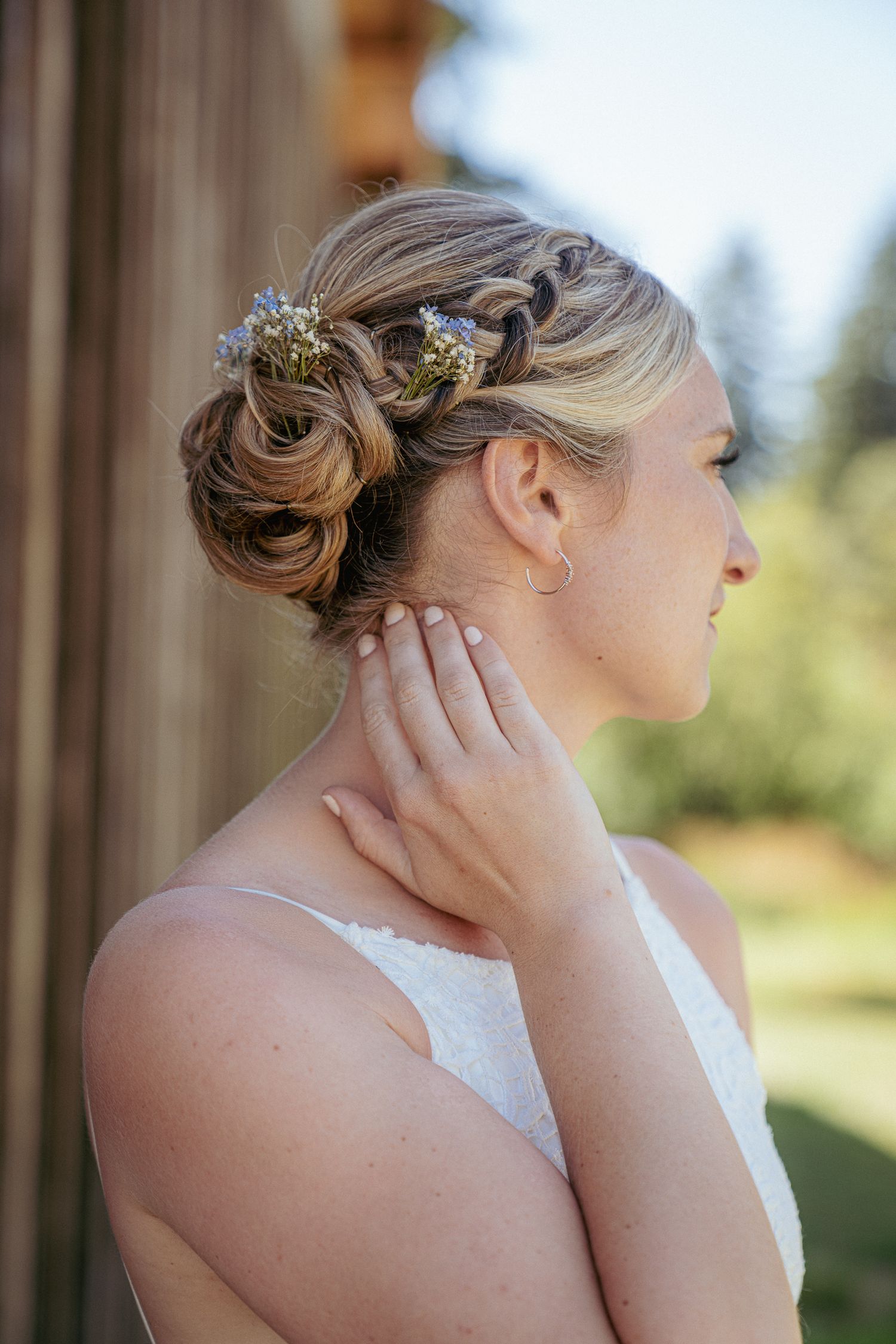 Bride shows off detailed braid and floral hairpiece, PNW elegance.