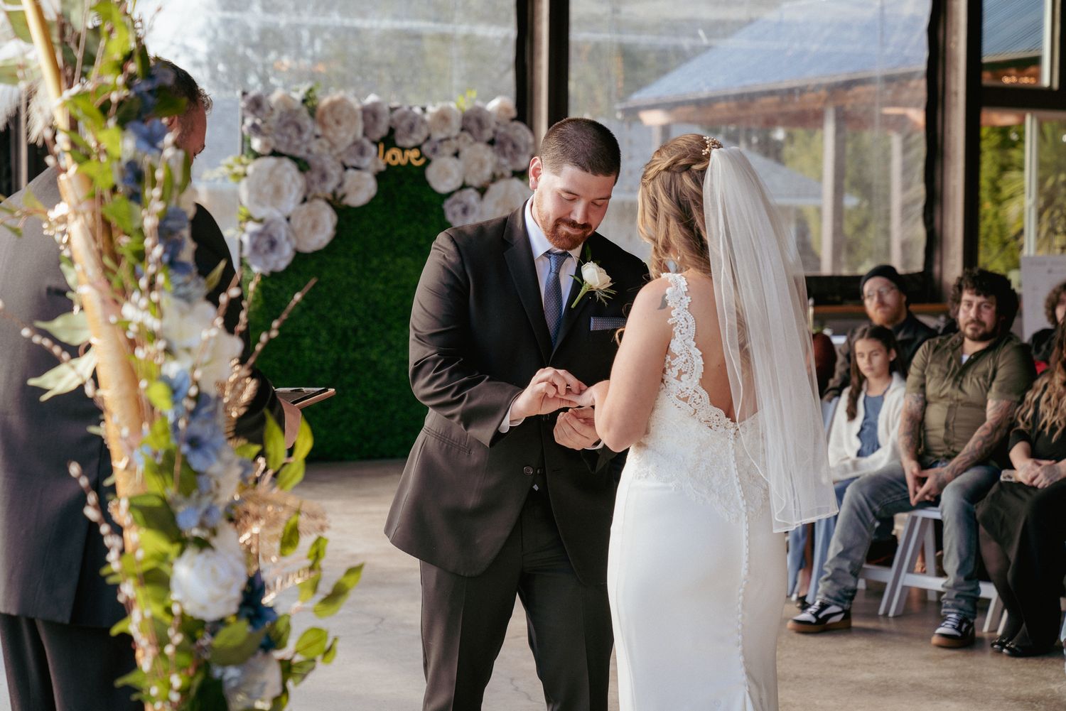 Groom places ring on bride’s finger, modern outdoor PNW vows.