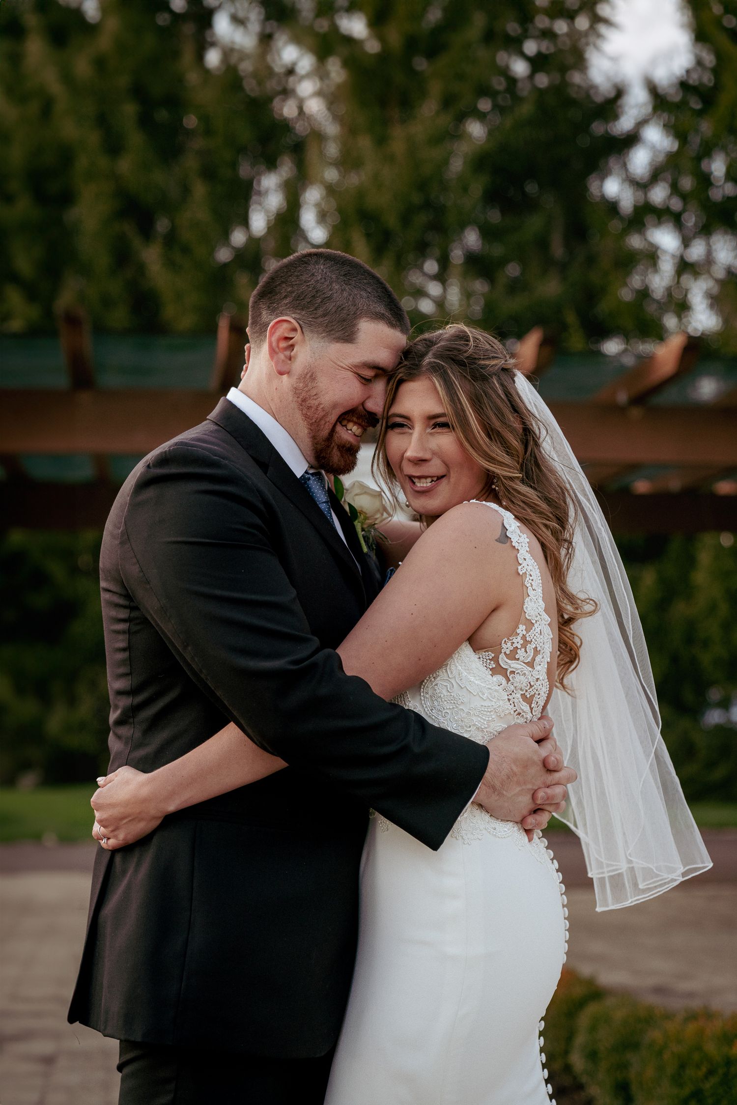 Groom hugs bride after vows, joyful moment at outdoor Oregon wedding.