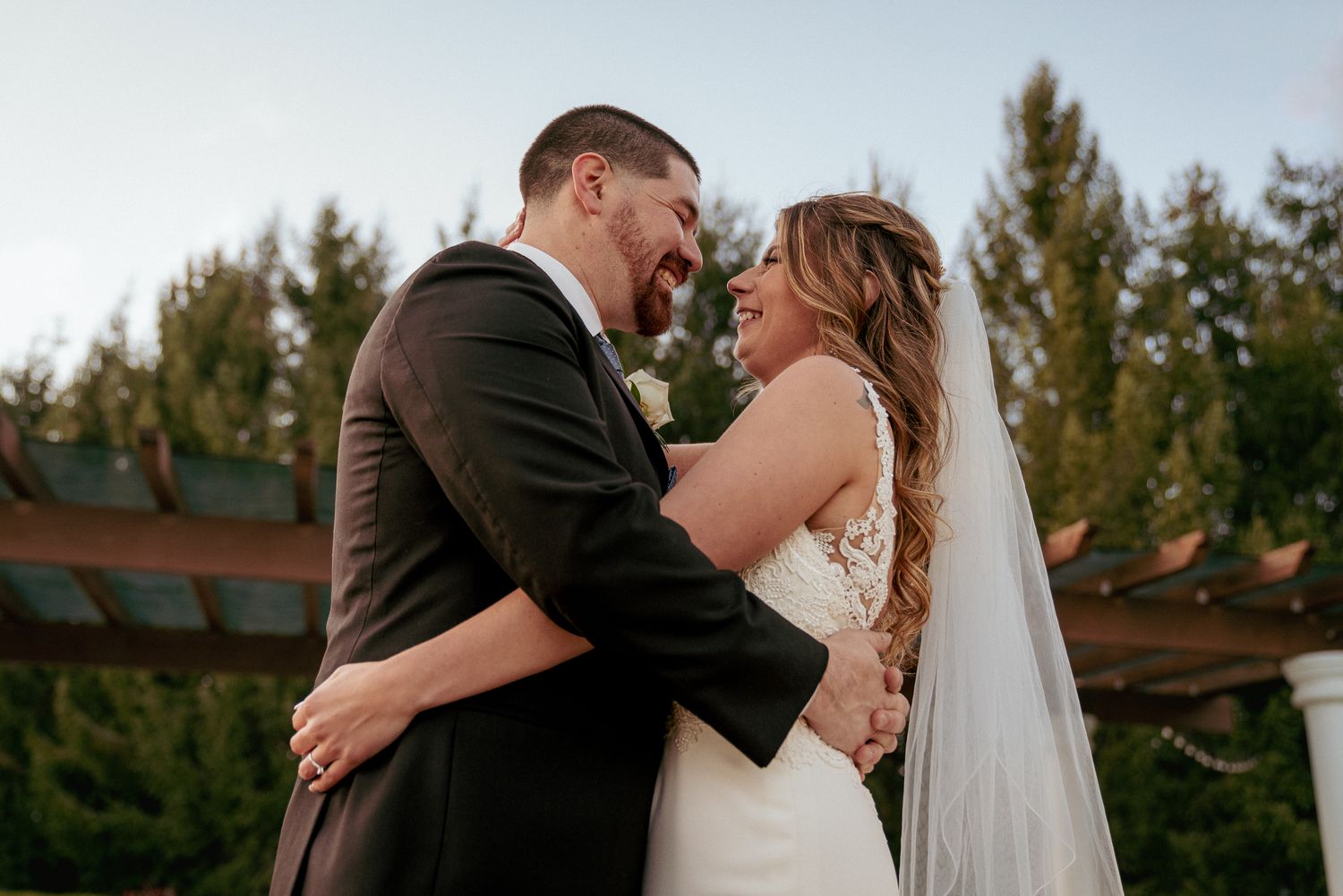 Groom embraces bride gently, heartfelt PNW wedding moment.