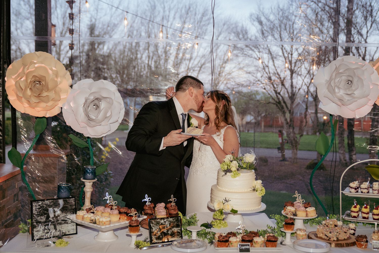 Couple cuts wedding cake together, spring garden reception in Oregon.