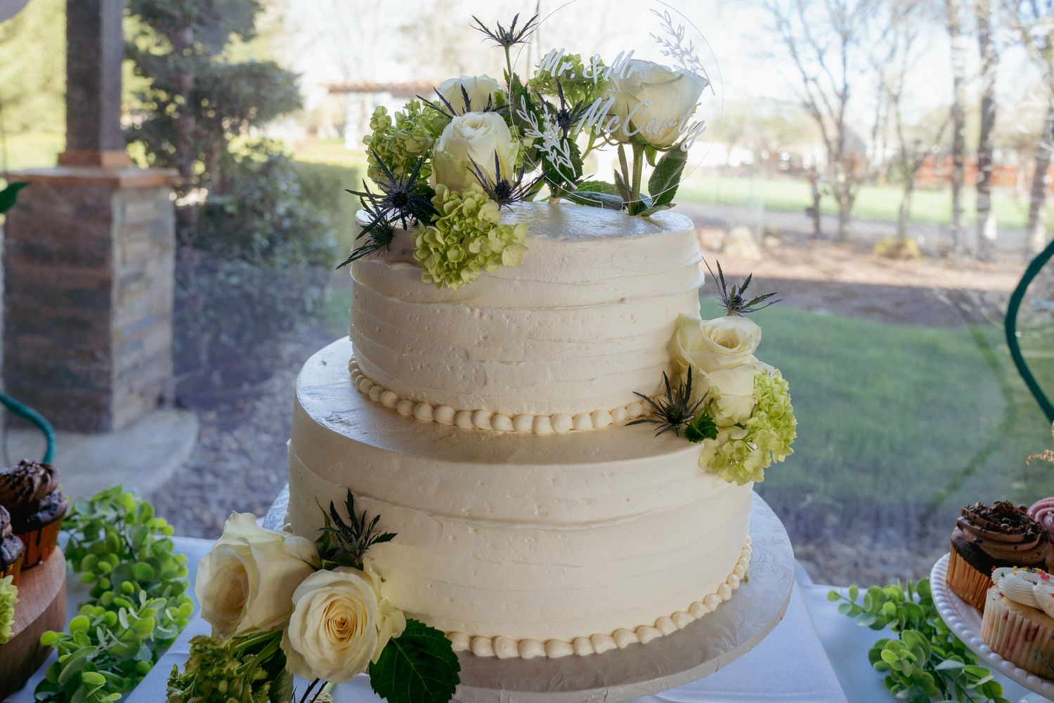 White wedding cake with succulents and roses, boho PNW dessert table.