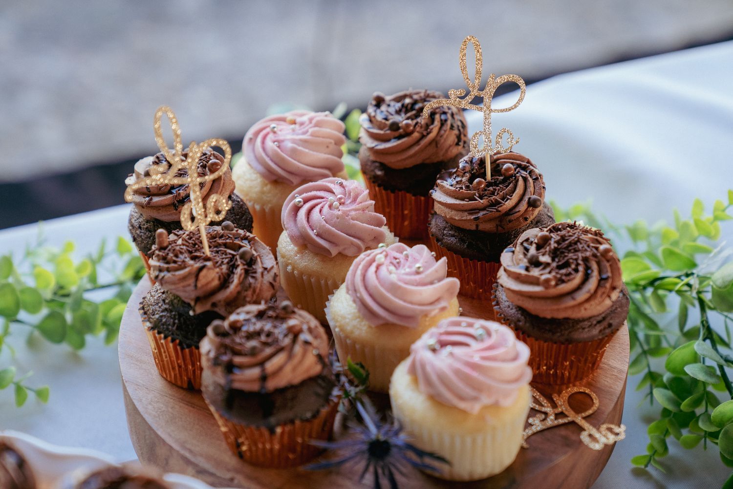 Assorted wedding cupcakes with gold toppers, rustic PDX dessert bar.