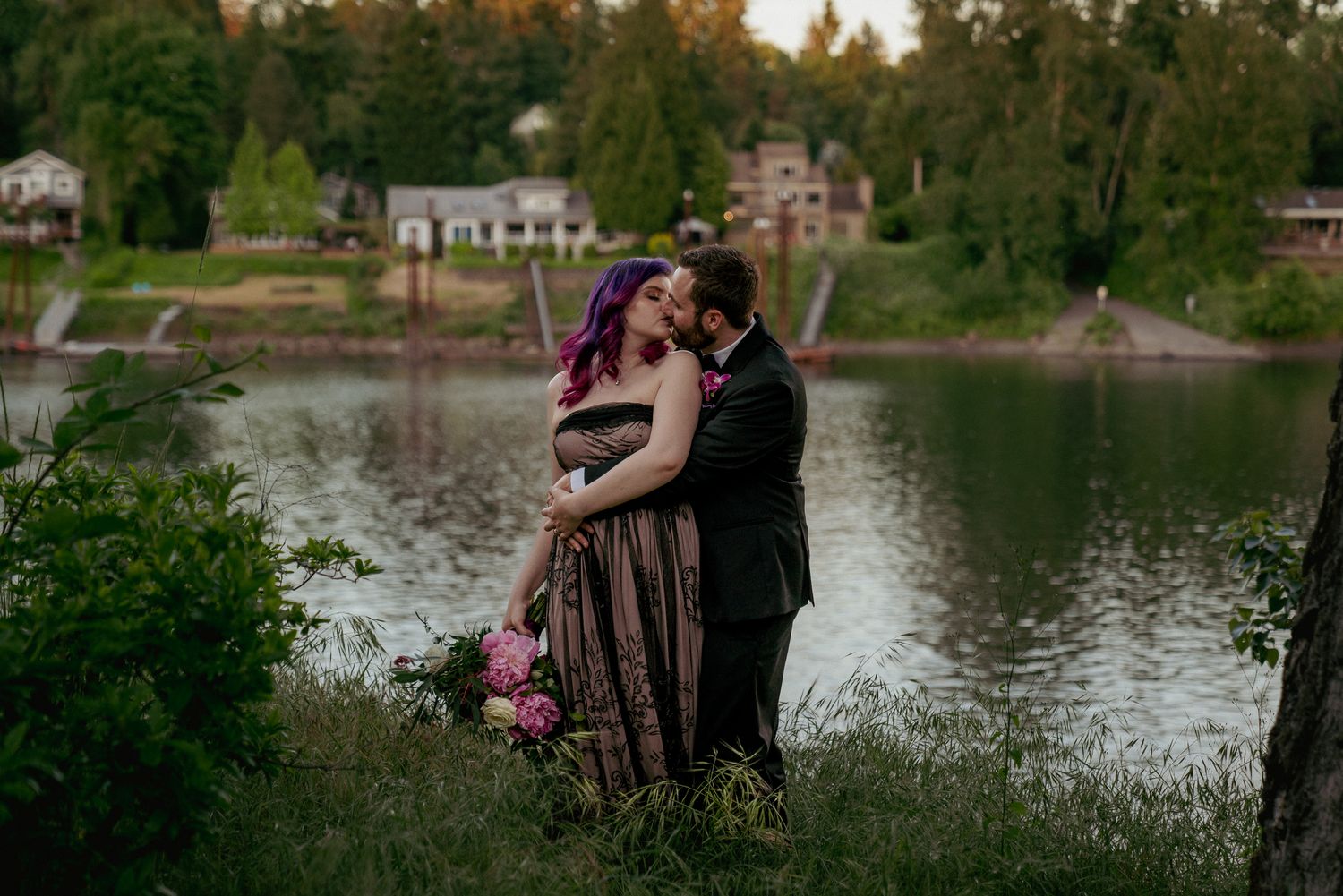 Bride and groom hug by Willamette River at dusk, dreamy PNW engagement session.