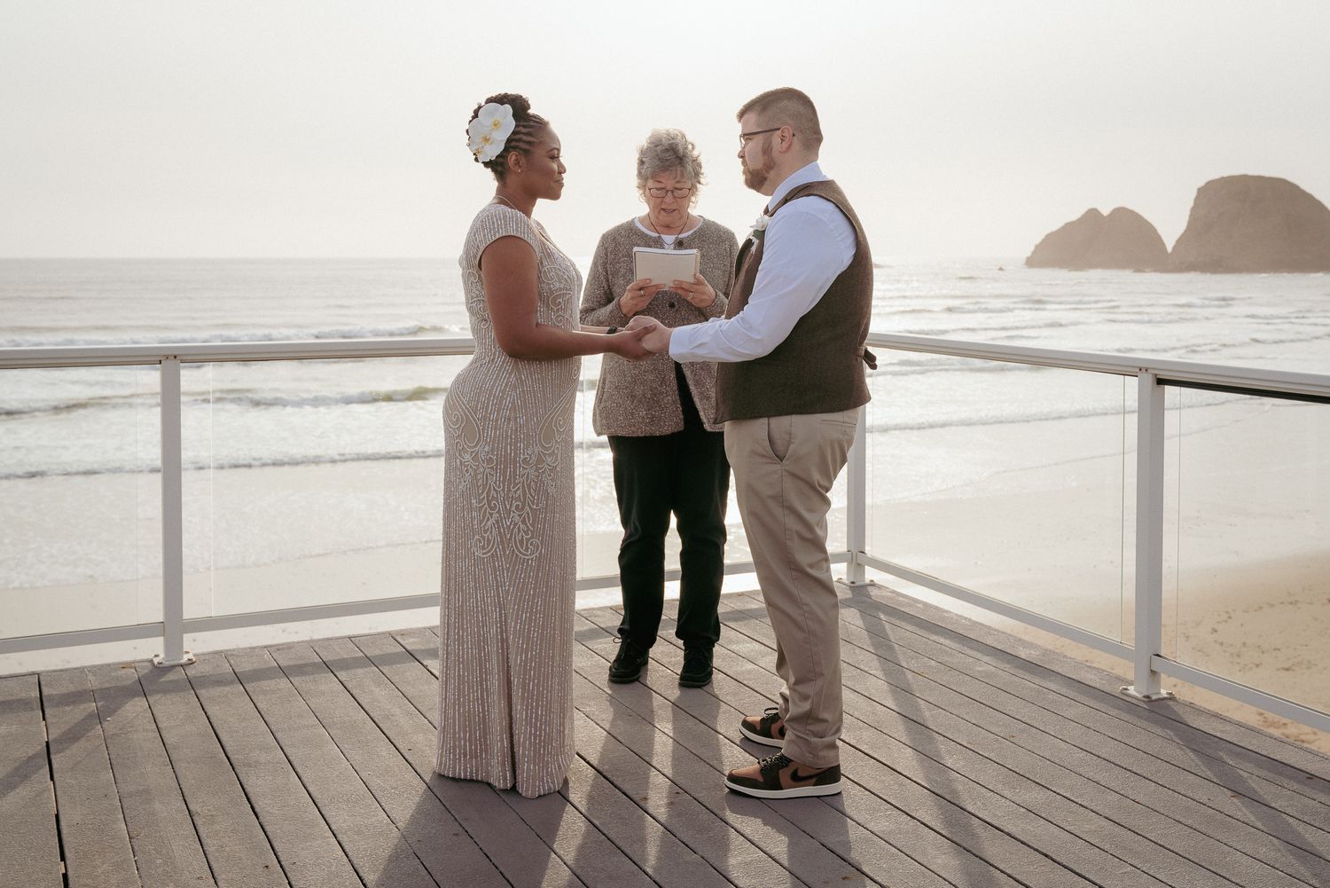 Bride and groom exchange vows on Oregon Coast deck overlooking pacific ocean. Elopement at the beach