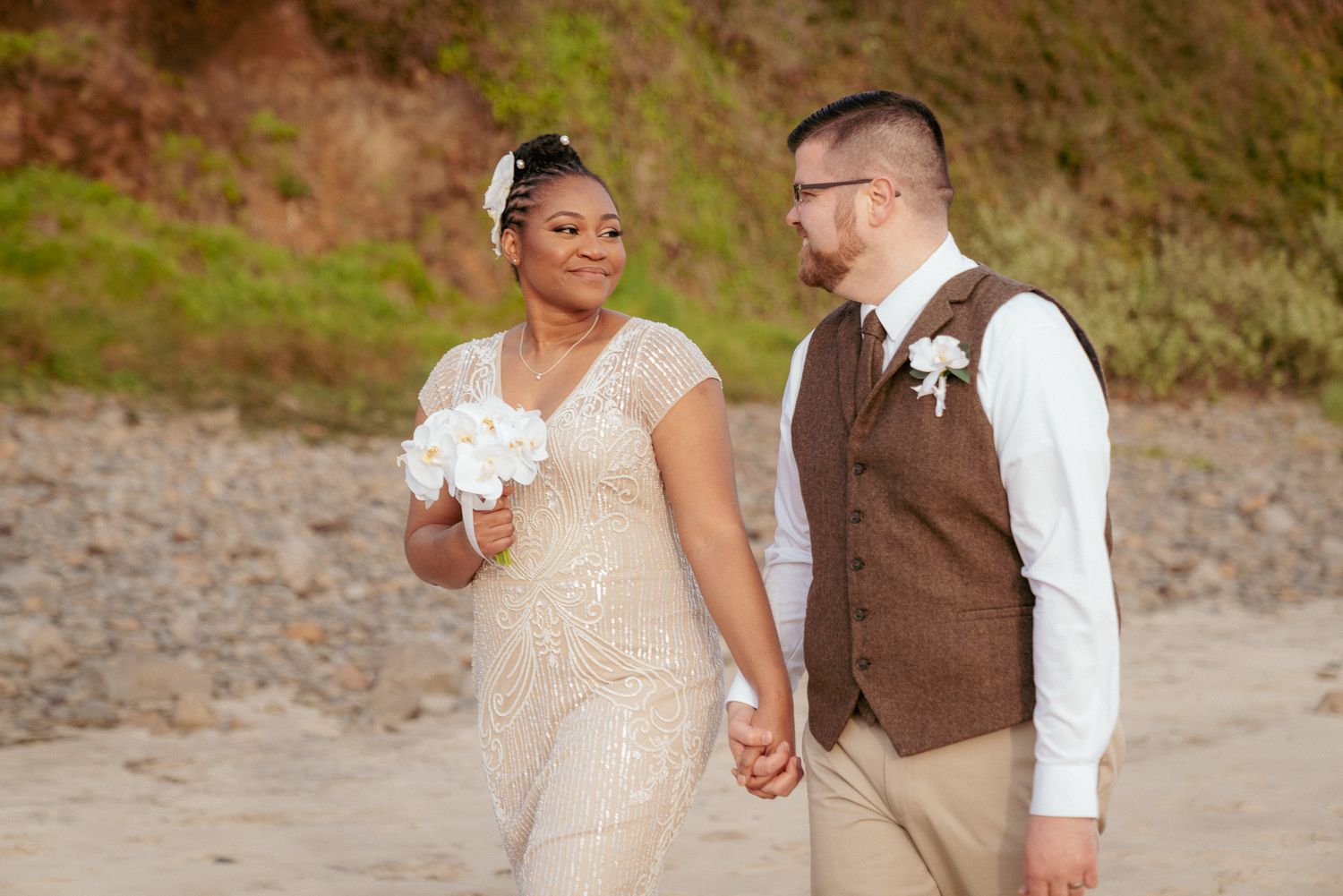 Black bride and white groom walk hand in hand, Oregon Coast vows.