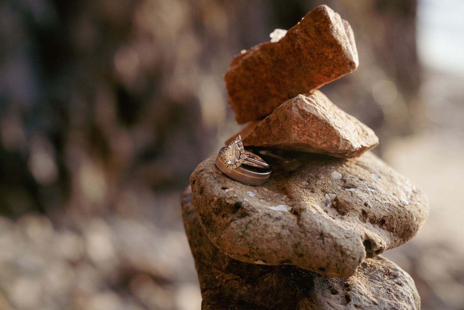 Balanced rocks near water with wedding rings on it, peaceful Oregon elopement scene.