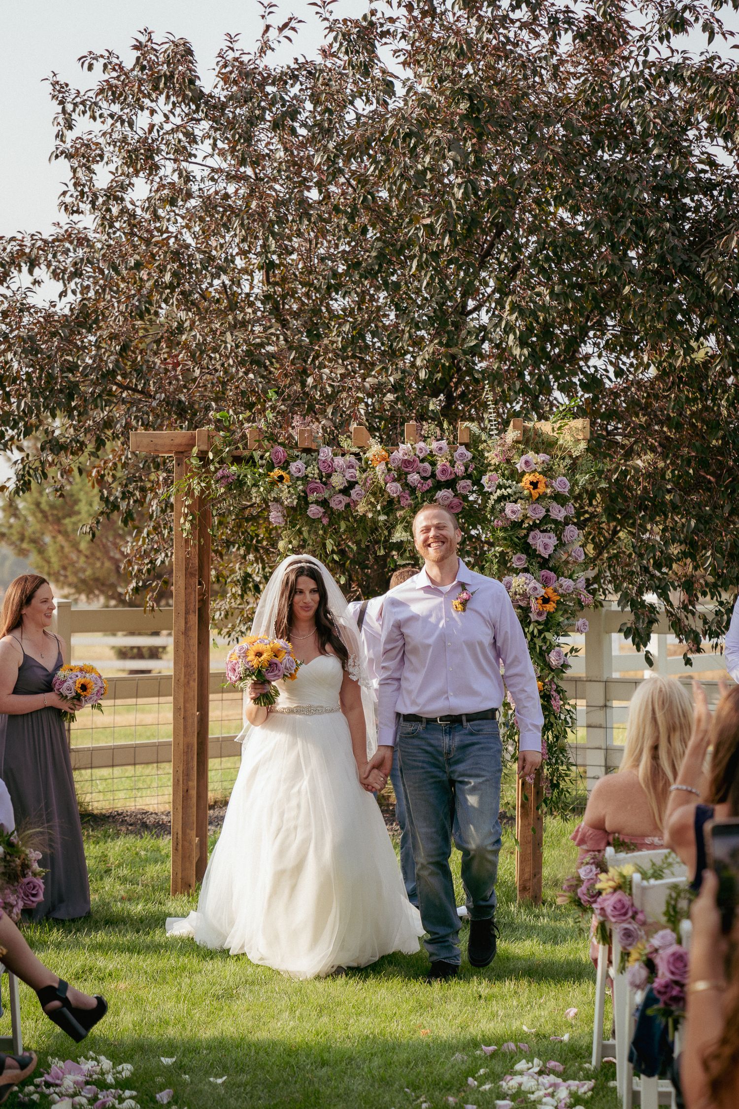Bride and groom exit wedding down floral aisle, Portland celebration.