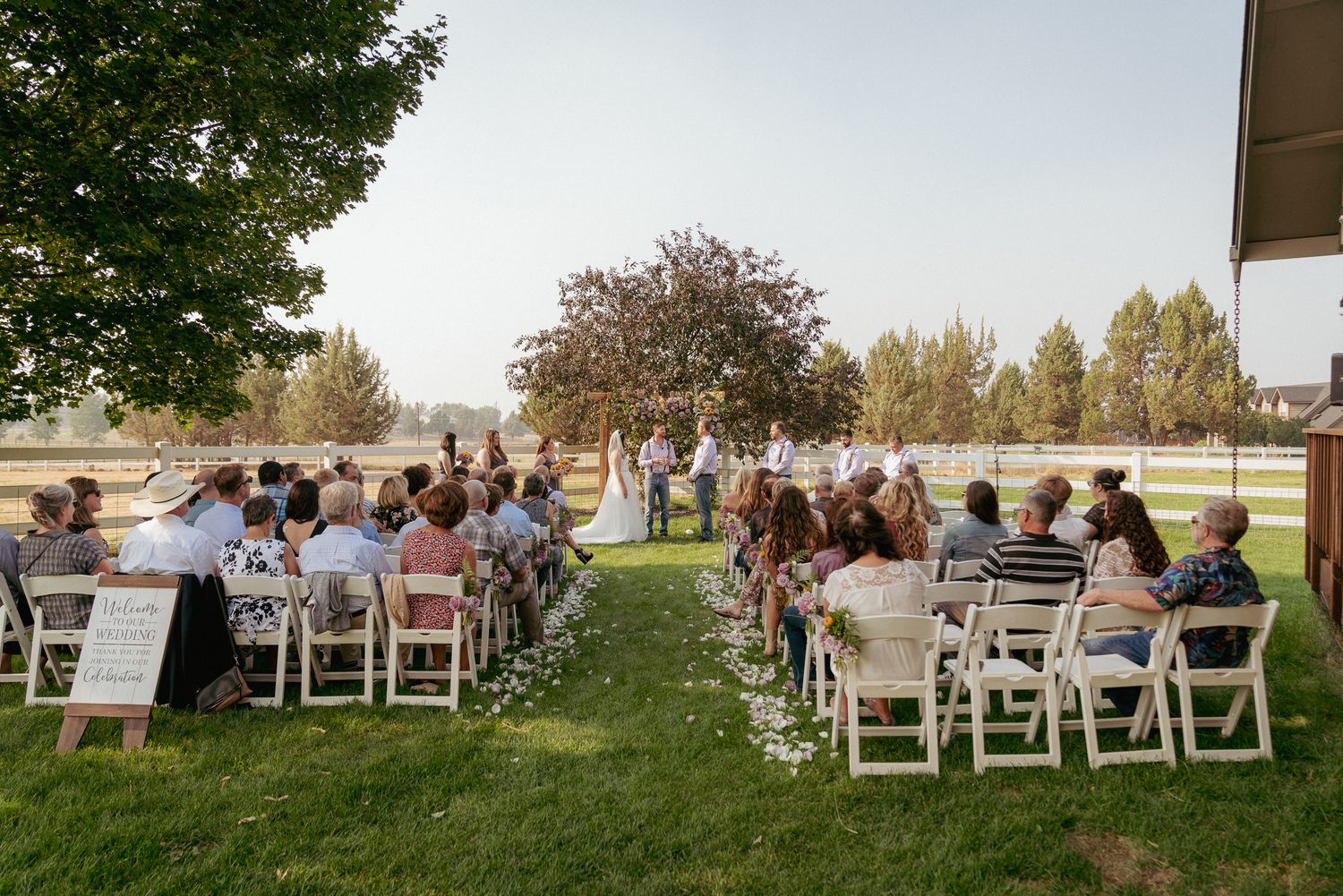 Backyard ceremony with guests seated under soft light, PNW charm.