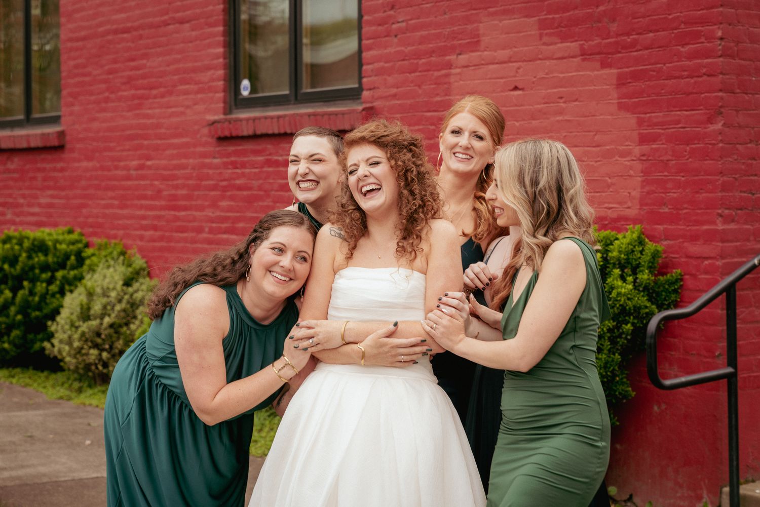 Bride laughs with bridesmaids in jewel tones, urban Portland wedding.