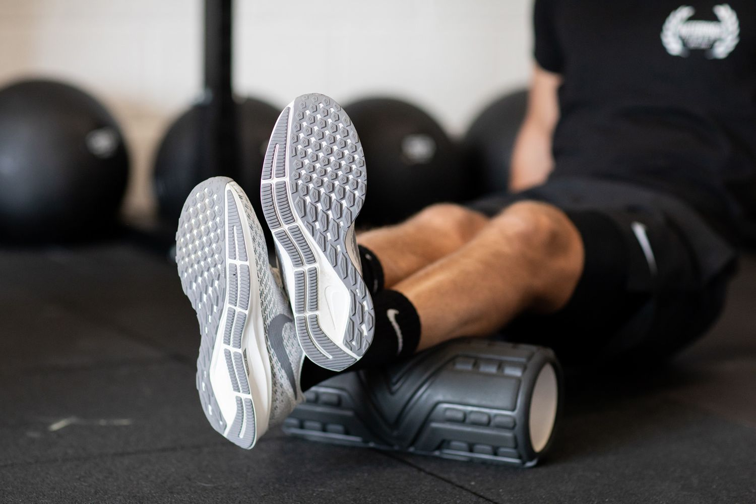 Athletic shoes and legs using a foam roller for muscle recovery during business branding photoshoot.